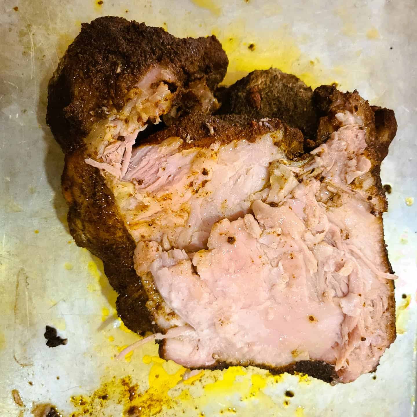 Place the pulled pork in a large baking pan and remove the fat cap of the pork butt. 