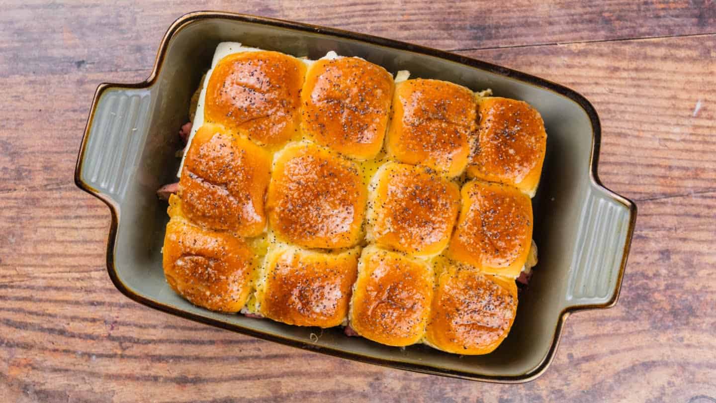 roast beef sliders in a baking pan  with poppy seeds