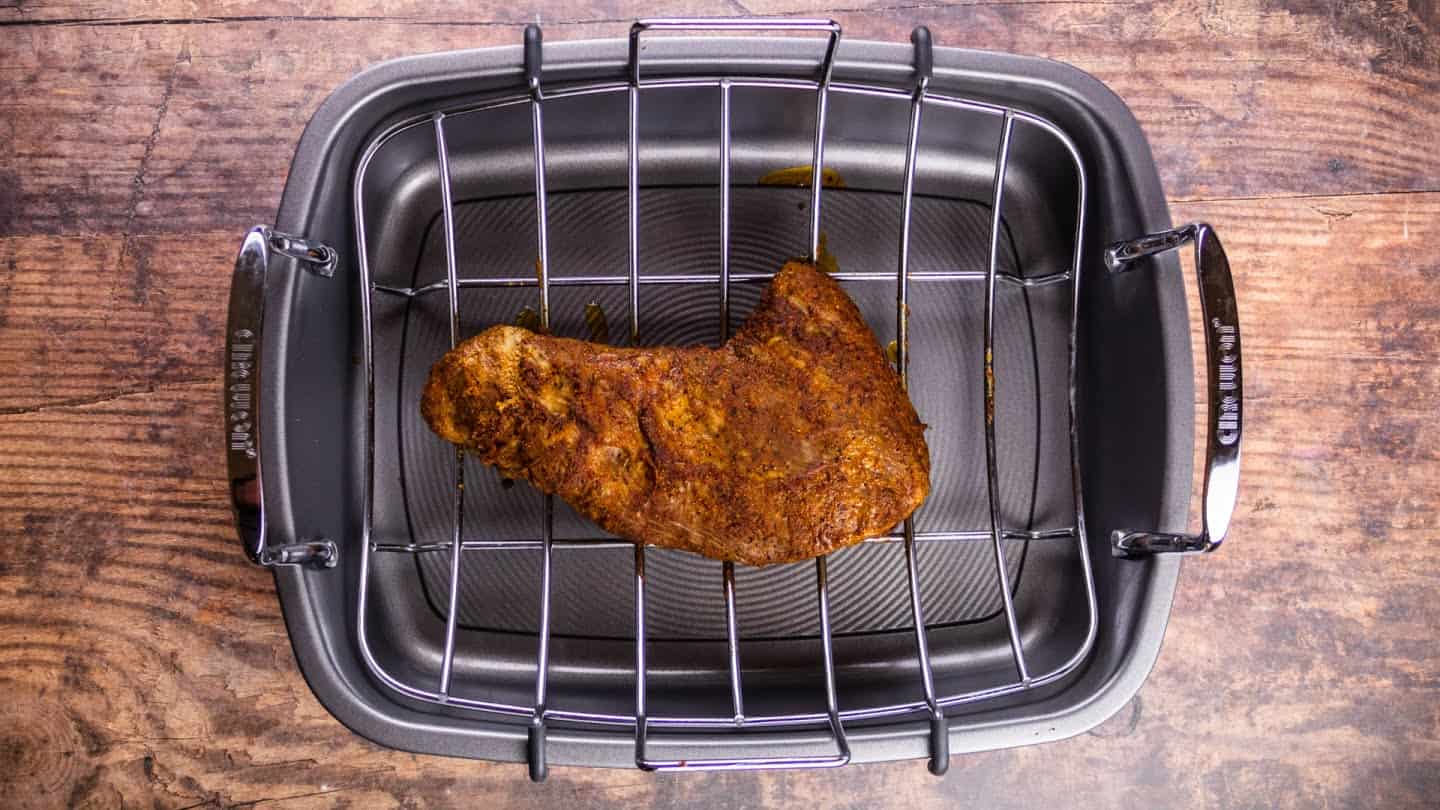 marinated tri-tip on a roasting pan with a rack,