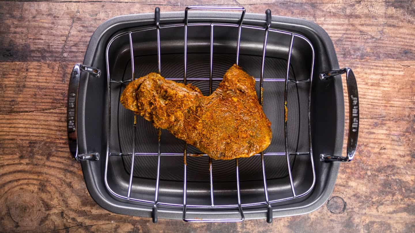 marinated tri-tip on a roasting pan with a rack,