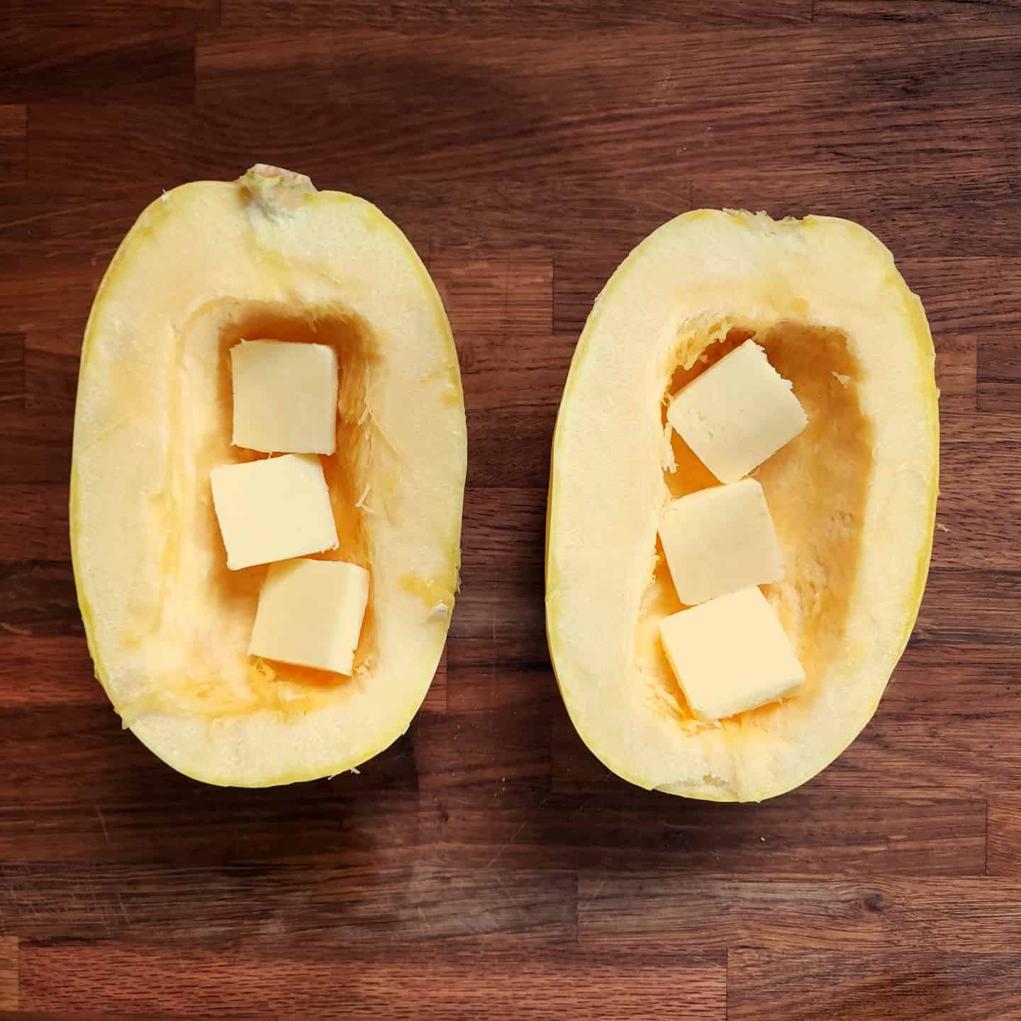 Cubed butter in spaghetti squash halves