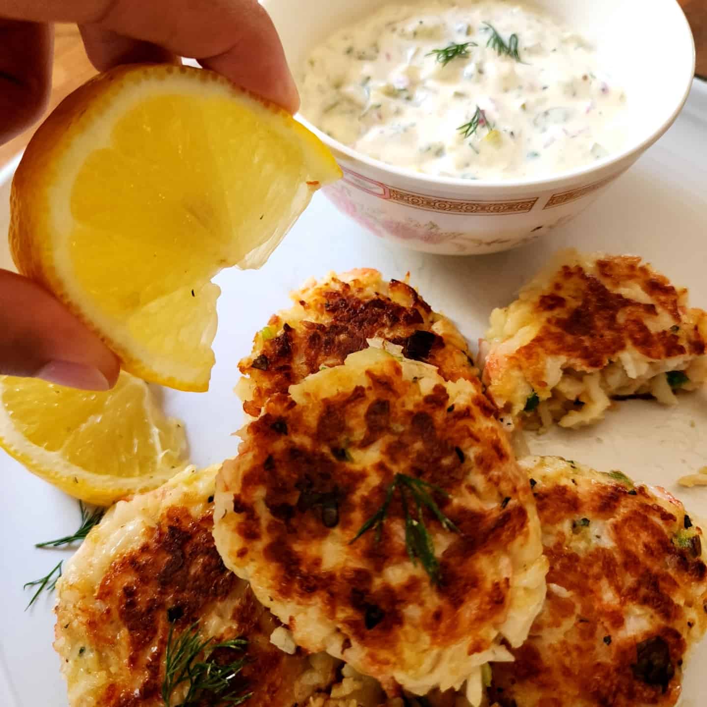 crab cake with tartar sauce and lemon wedge