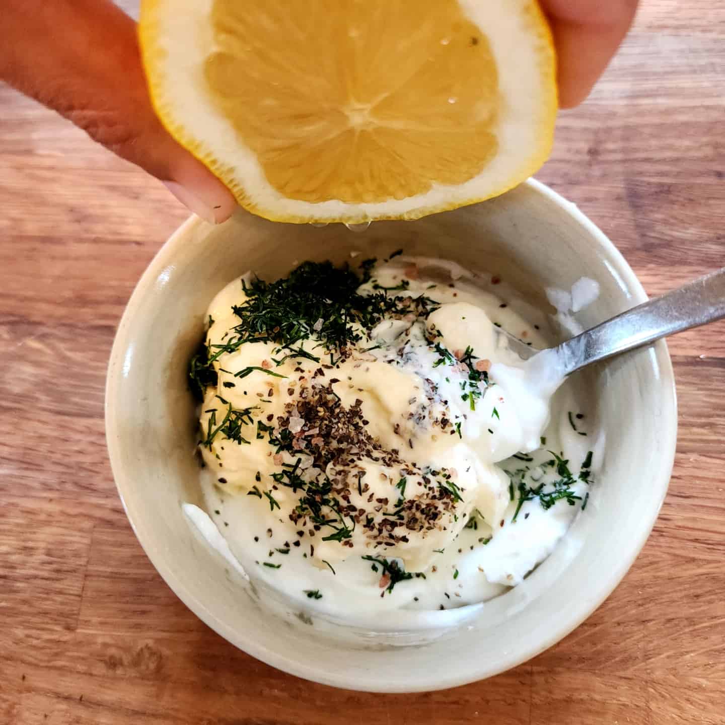 combination of Greek yogurt, mayo, lemon juice, and fresh dill into a bowl