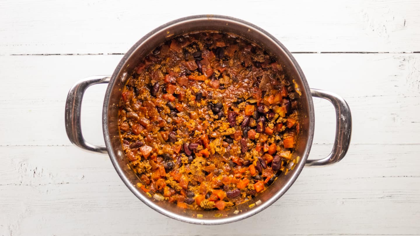 Add the 2 cans beans, cooked beef, and diced tomatoes with chiles into the pot and turn the heat down to medium-low.