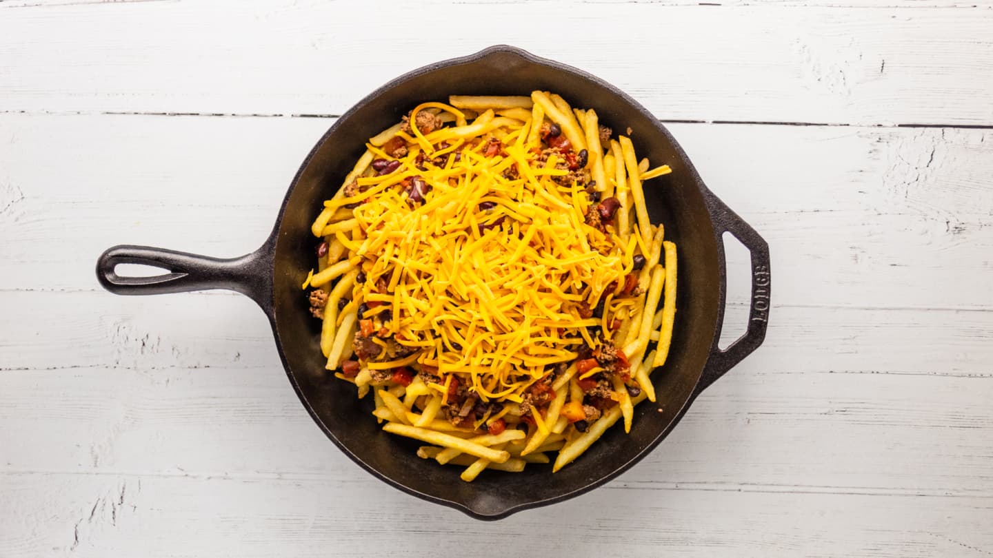 Spoon the homemade chili over the top of the fries, followed by the shredded cheese,