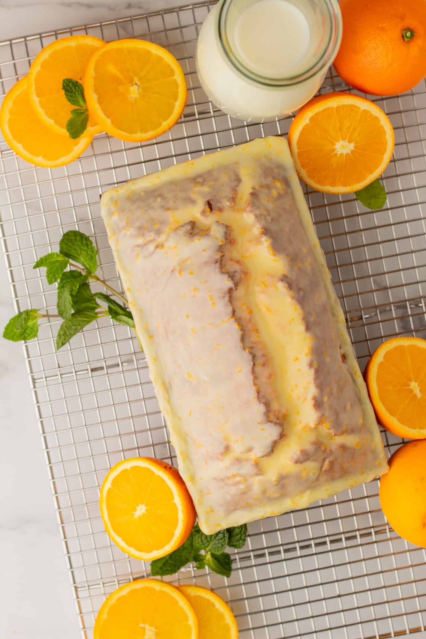 Let the cake cool completely before decorating it with a dusting of powdered sugar, orange slices, and mint leaves