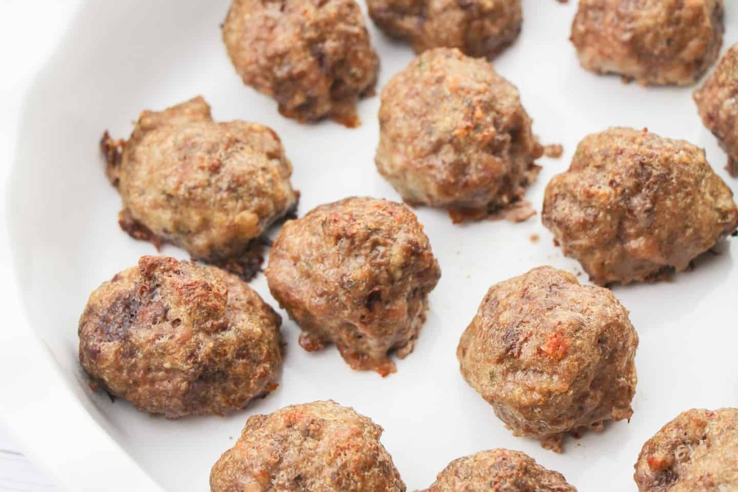 Place the meatballs 1 inch apart on a parchment-lined baking sheet and bake them for 18 minutes.
